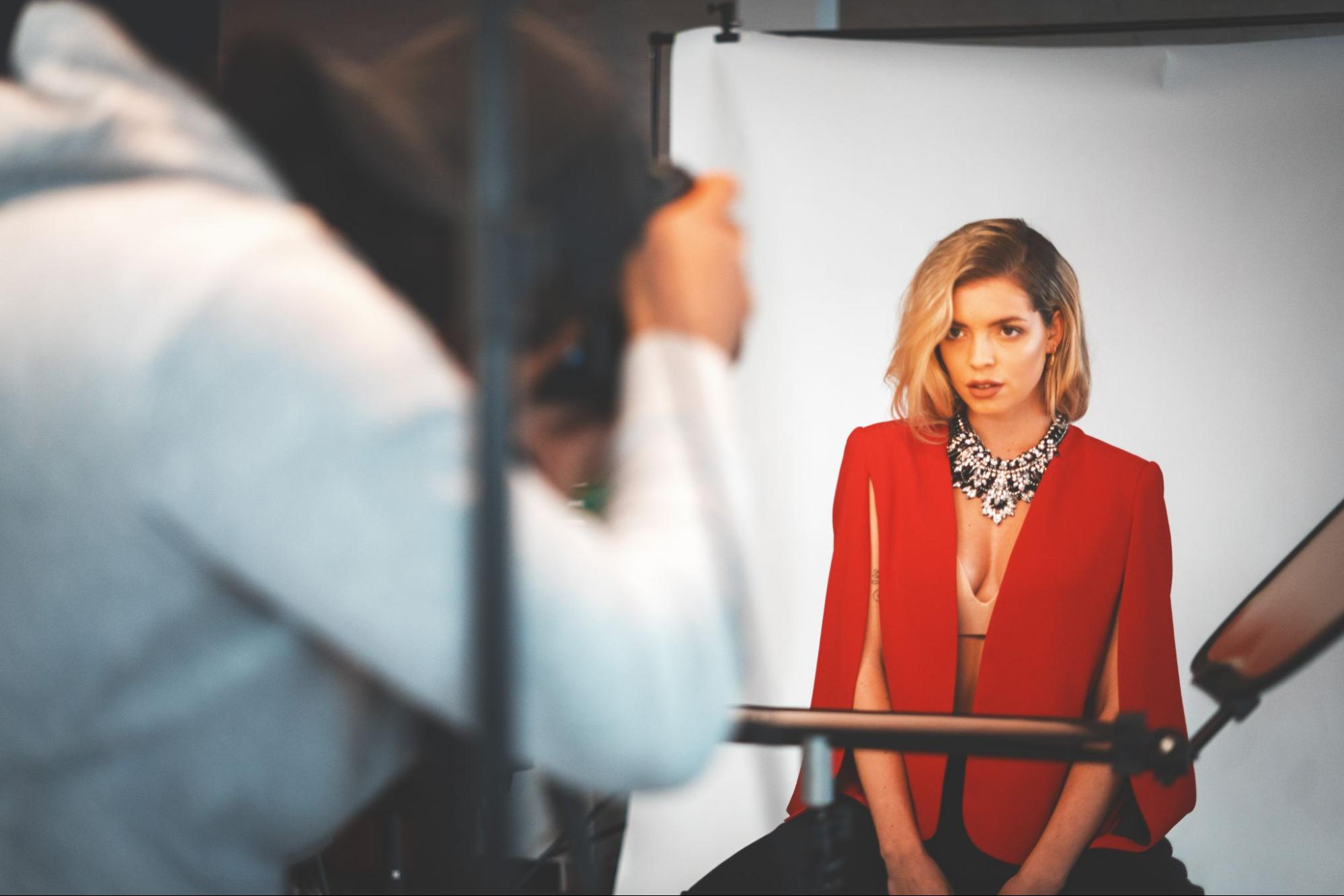 a model in glamorous jewelry poses for a photoshoot in a studio.