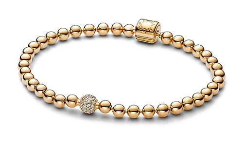 A yellow gold beaded bracelet with pave diamond accents from Pandora.