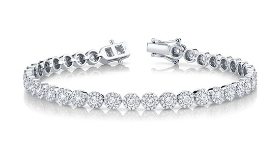 A silver diamond tennis bracelet with halo set diamonds all the way around