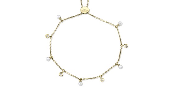 A gold Shy Creation bracelet with pearl and diamond stations