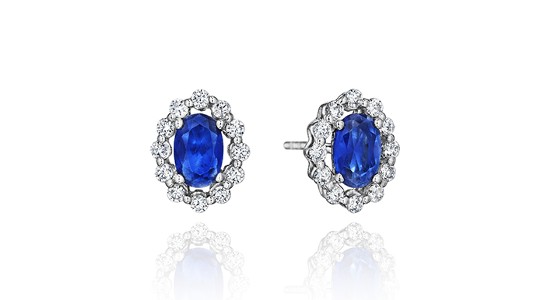 A pair of sapphire stud earrings with diamond halos