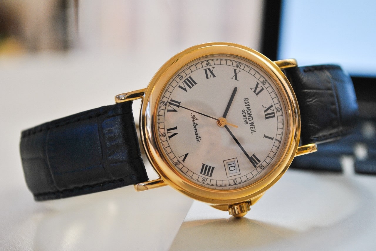 Timepiece with leather strap and gold case