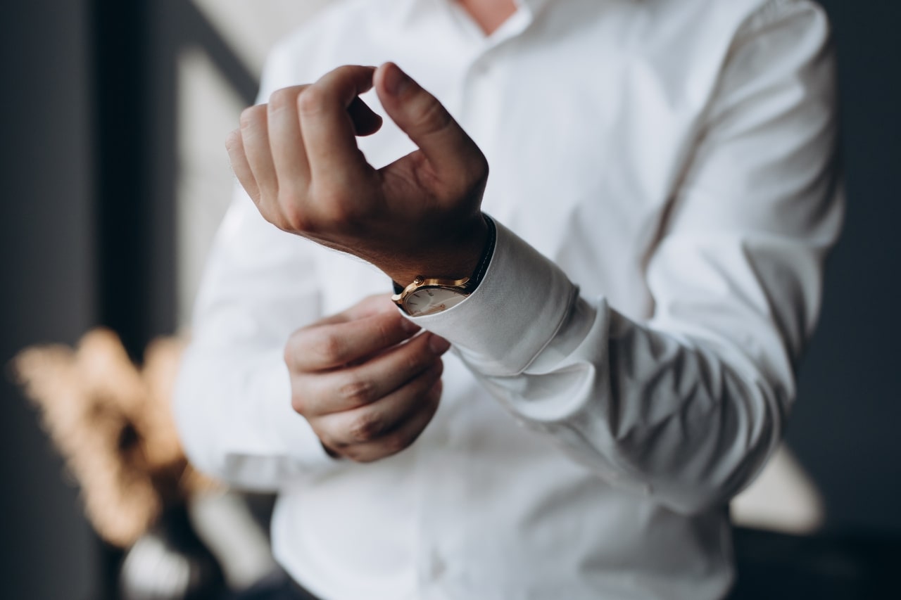 Man wearing a fine watch adjusting his sleeves