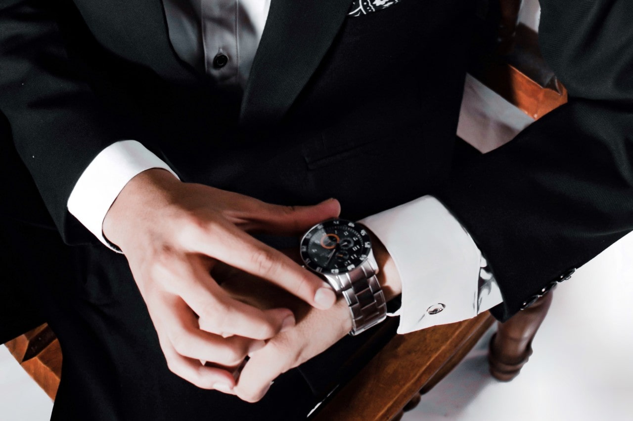 Man in a suit wearing a black and silver watch