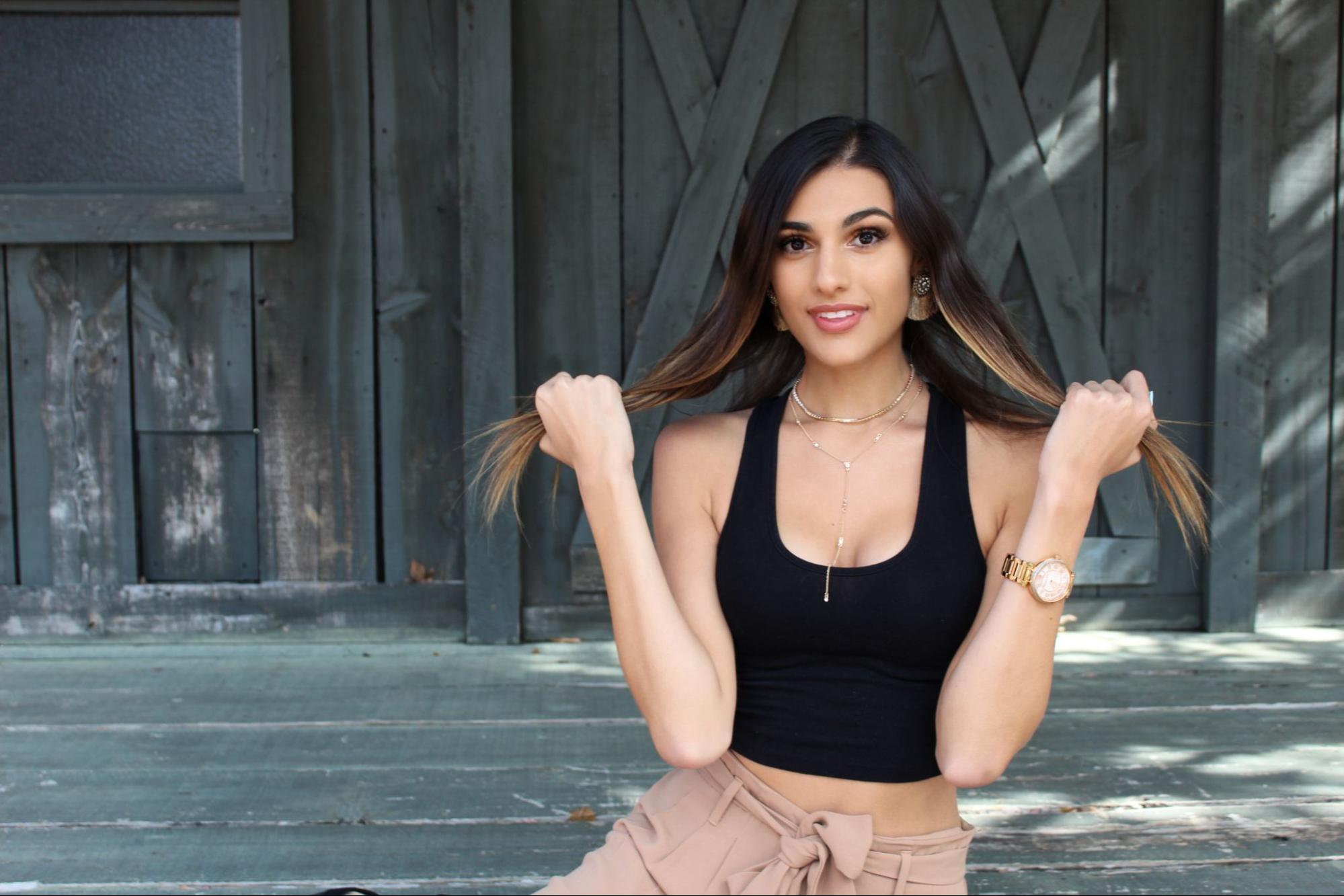 Fashionable woman wearing jewelry and holding her hair in her hands