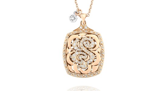a rose gold pendant necklace featuring the letter “S” dotted with diamonds