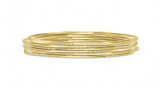 a layered yellow gold bangle with diamond accents