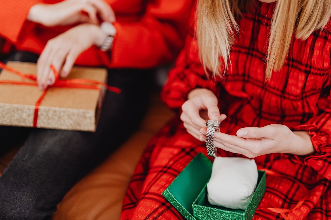 A woman inspects a watch she just unwrapped on Christmas Day.