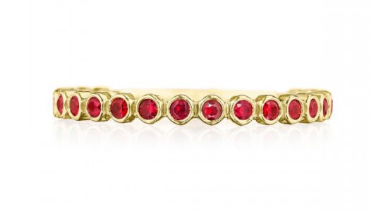 a yellow gold wedding band featuring round cut rubies in bezel settings