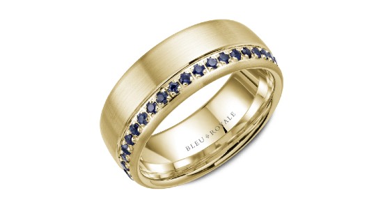 a large yellow gold wedding band featuring small round cut sapphires