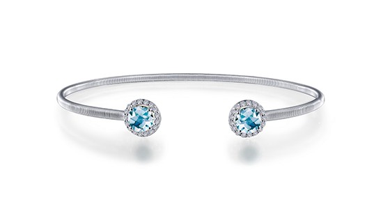 a sterling silver cuff bracelet featuring two round cut aquamarine gems