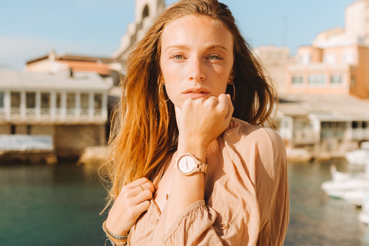 A young woman wearing a minimalist wrist watch.
